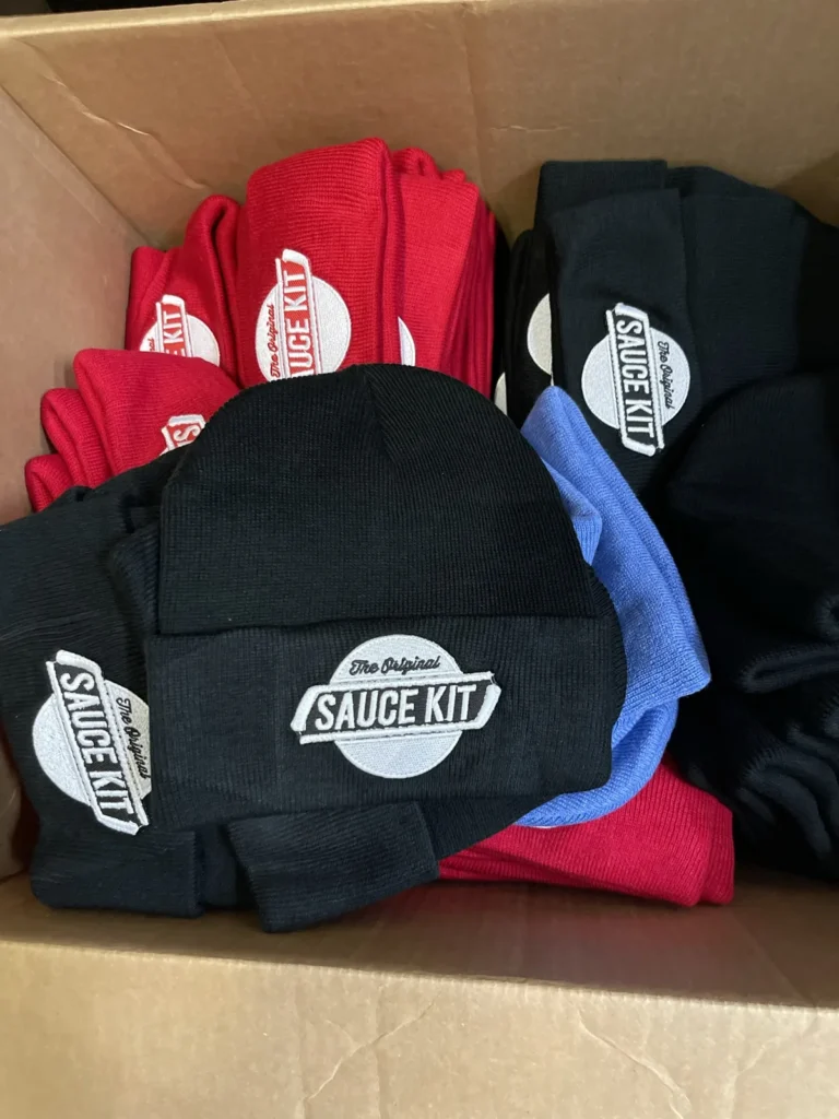 Red, black and blue beanies with matching white Sauce Kit logos