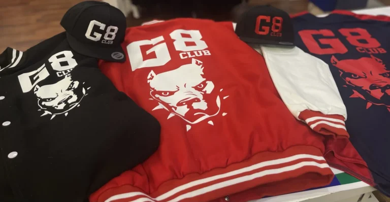 Red and black varsity jackets and caps with G8 Club designs