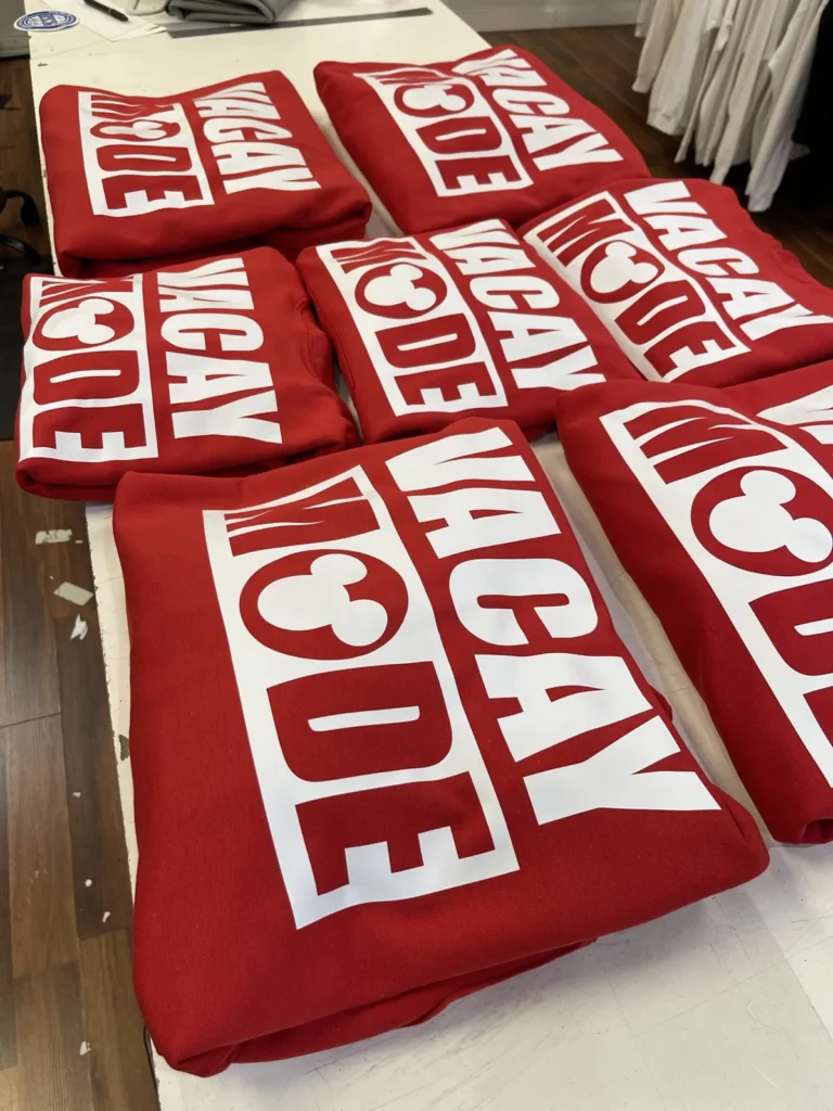 Stacked red shirts with matching white Vacay Mode designs