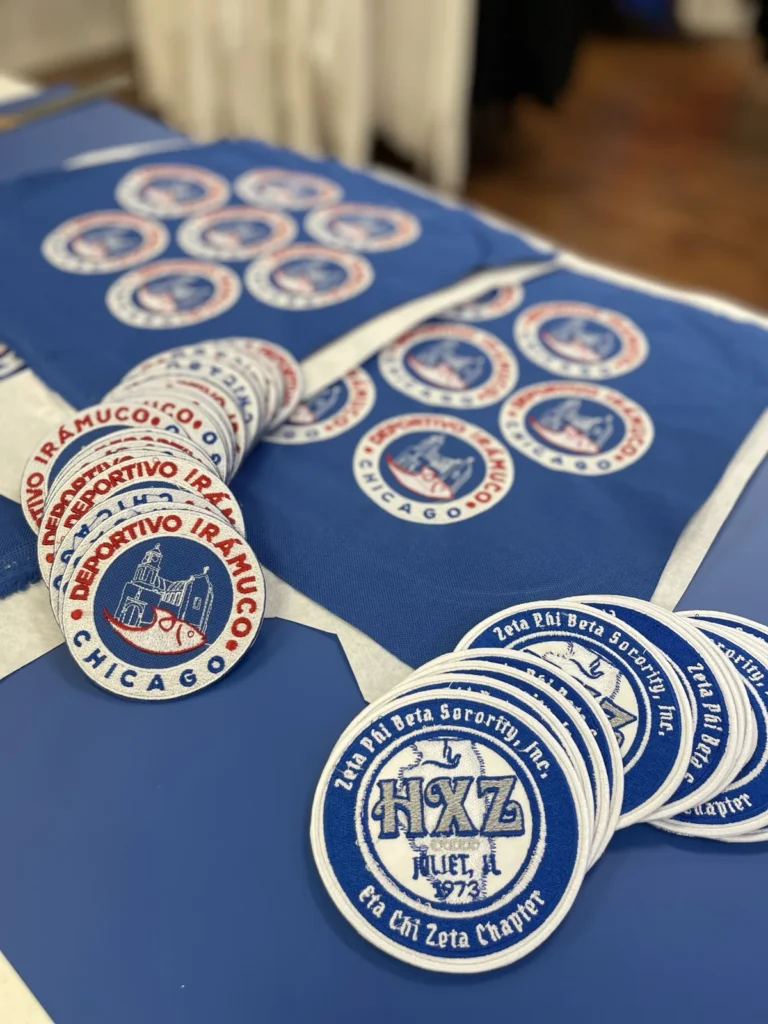 Batch of matching circular logo patches arranged on blue fabric