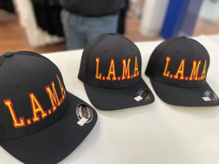 Three black caps with matching red and yellow L.A.M.A. lettering