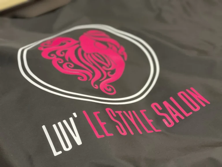 Pink and white salon logo design on dark fabric