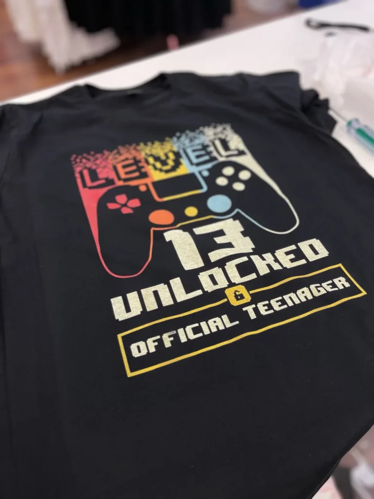 Black shirt with a colorful Level 13 gaming controller design