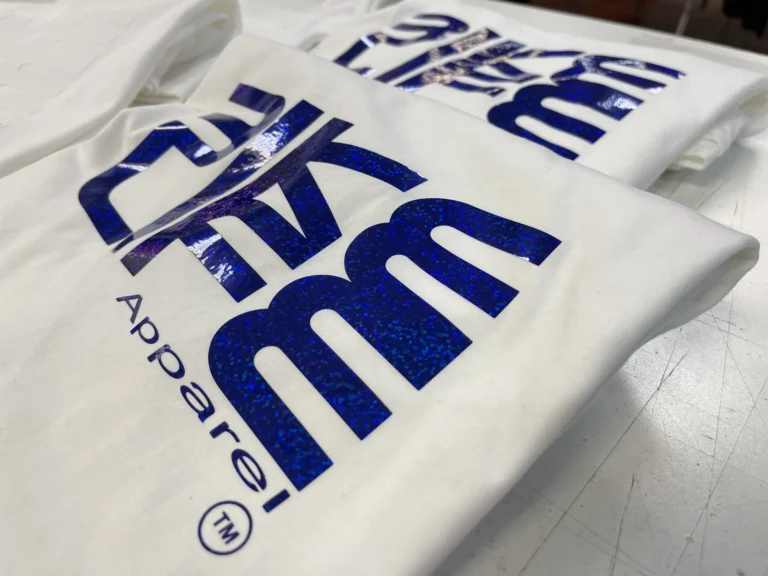 Blue glitter lettering on folded white apparel