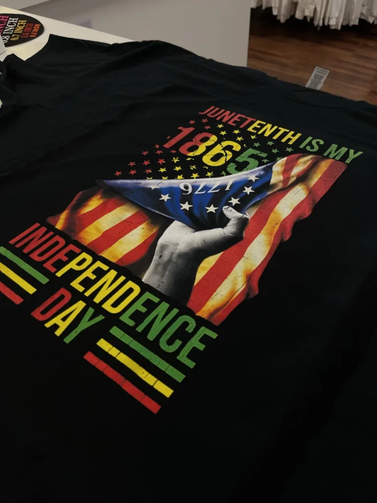 Black shirt with a colorful Juneteenth graphic and lettering