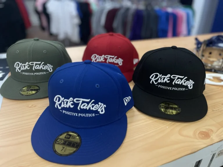 Four caps in different colors with matching white Risk Takers lettering